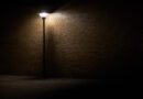 Inseguridad nocturna: farola solitaria iluminando una calle oscura de noche