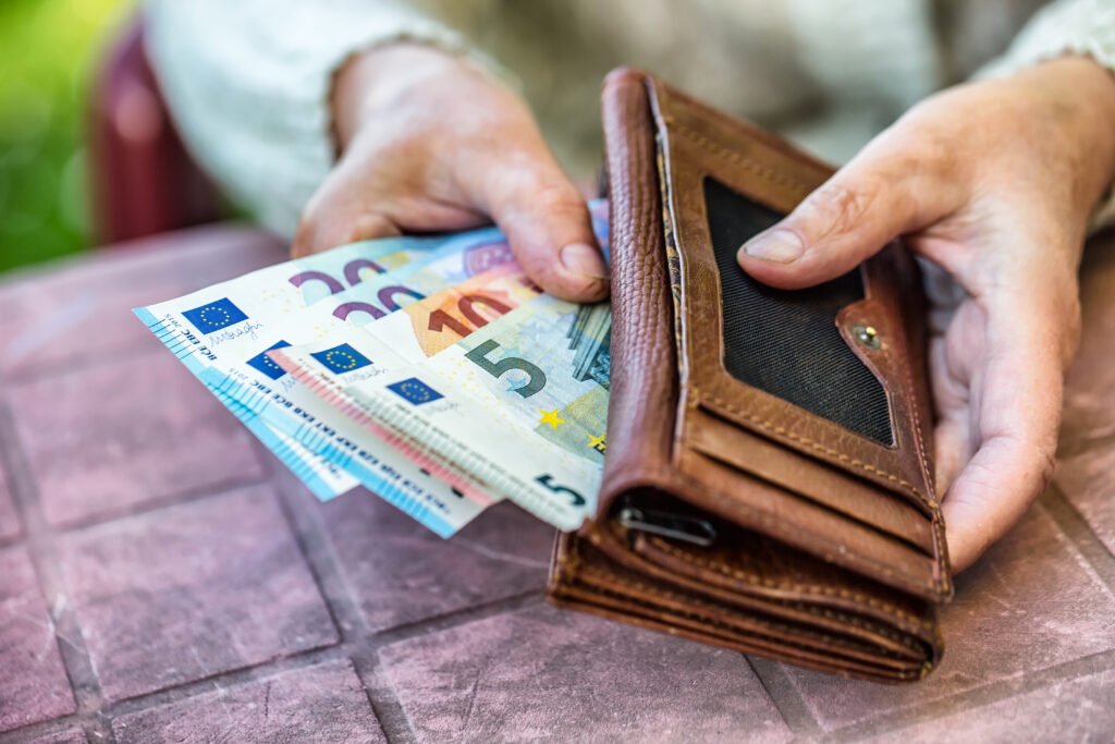 jubilaciones de agosto: una jubilada sostiene una billetera con dinero