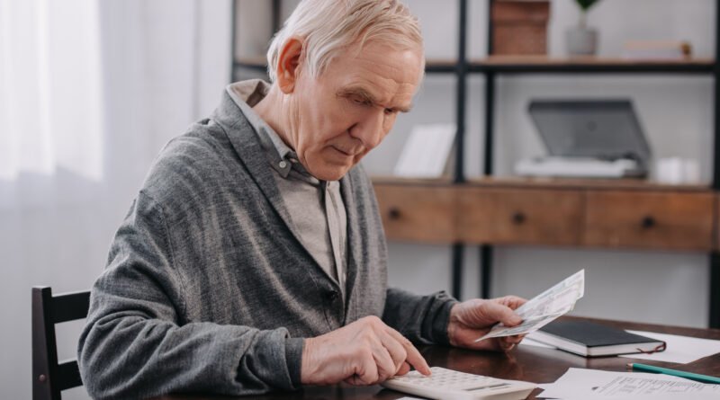jubilaciones de septiembre: adulto mayor con calculadora y dinero