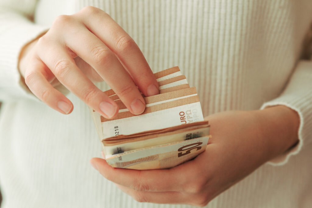 jubilaciones de septiembre: manos contando billetes de dinero en efectivo