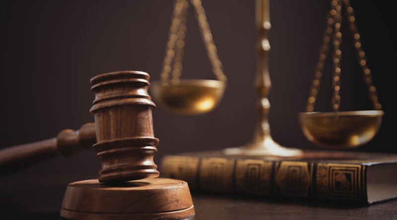 Juicio a Lotocki: mazo y balanza de la justicia sobre un escritorio