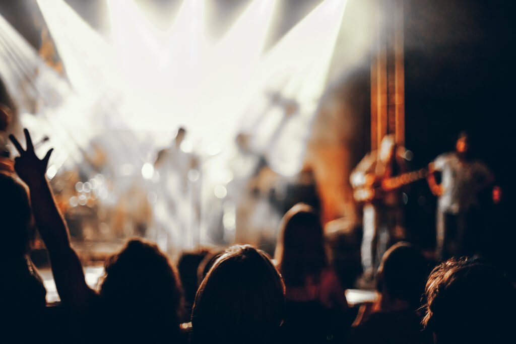Lali Espósito: siluetas del público frente a las luces de un escenario de recital