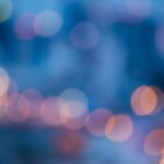 L-Gante y Wanda Nara: luces de neón de una calle de noche con bokeh