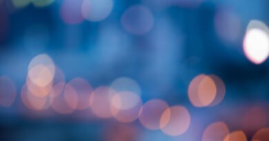 L-Gante y Wanda Nara: luces de neón de una calle de noche con bokeh