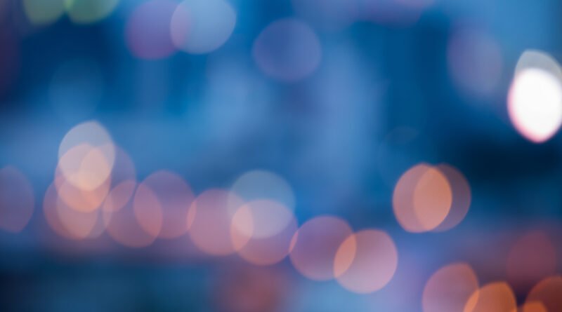 L-Gante y Wanda Nara: luces de neón de una calle de noche con bokeh