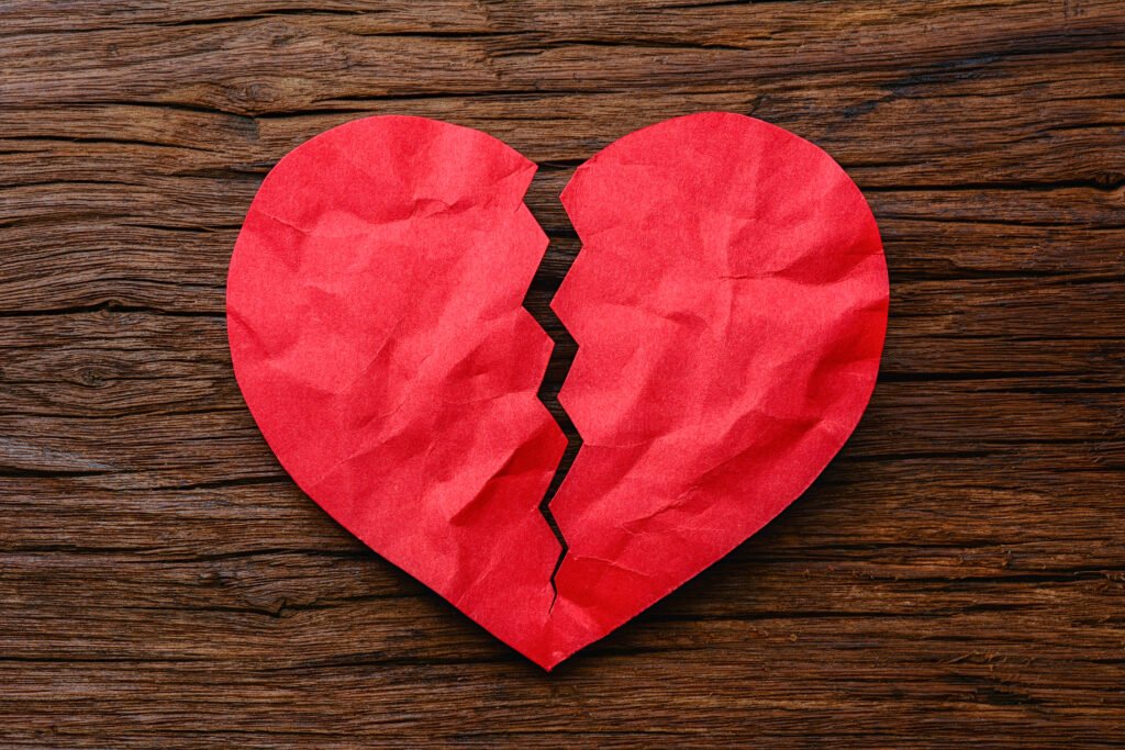 Luck Ra: mano sostiene un corazón de papel roto