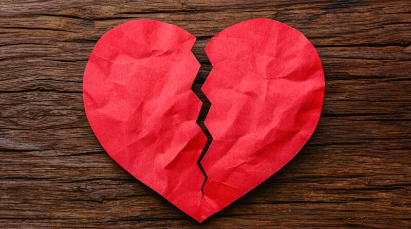 Luck Ra: mano sostiene un corazón de papel roto