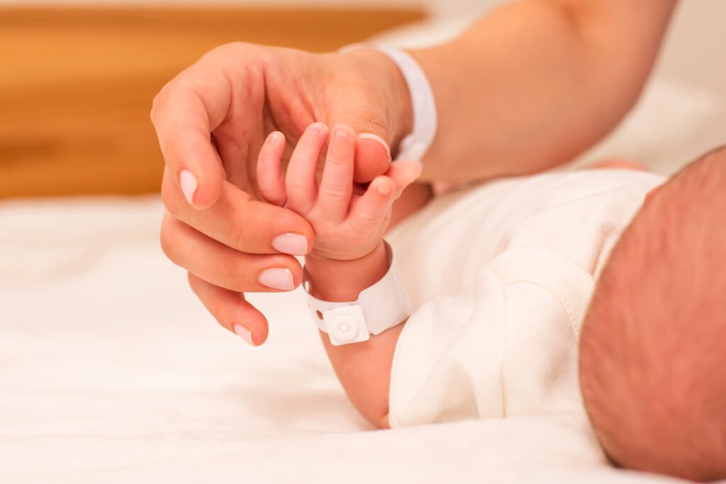 madre de mayor edad: manos de una madre sosteniendo a su bebé recién nacido