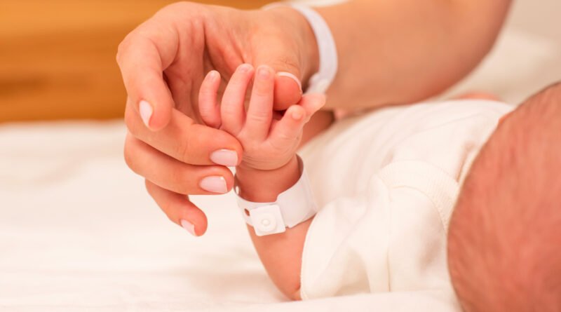 madre de mayor edad: manos de una madre sosteniendo a su bebé recién nacido