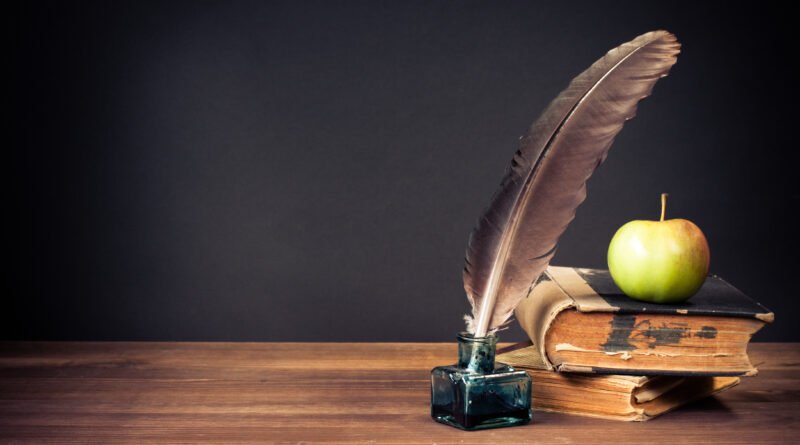 Mi brillante carrera: pluma, libros antiguos y bodegón de época sobre una mesa