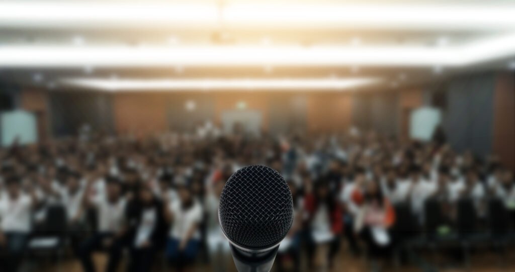 Milei ante empresarios: auditorio de conferencia con atril iluminado