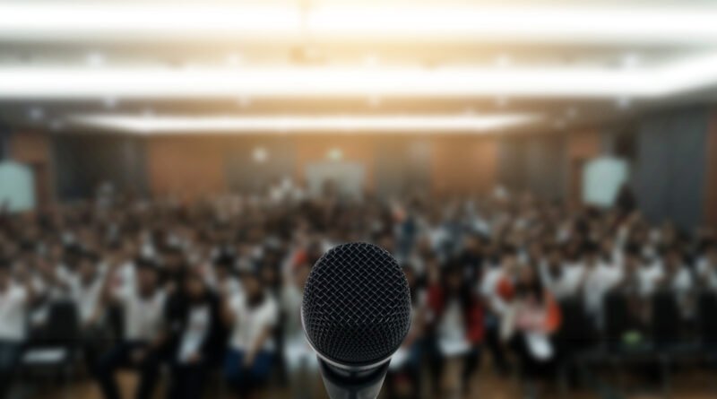 Milei ante empresarios: auditorio de conferencia con atril iluminado
