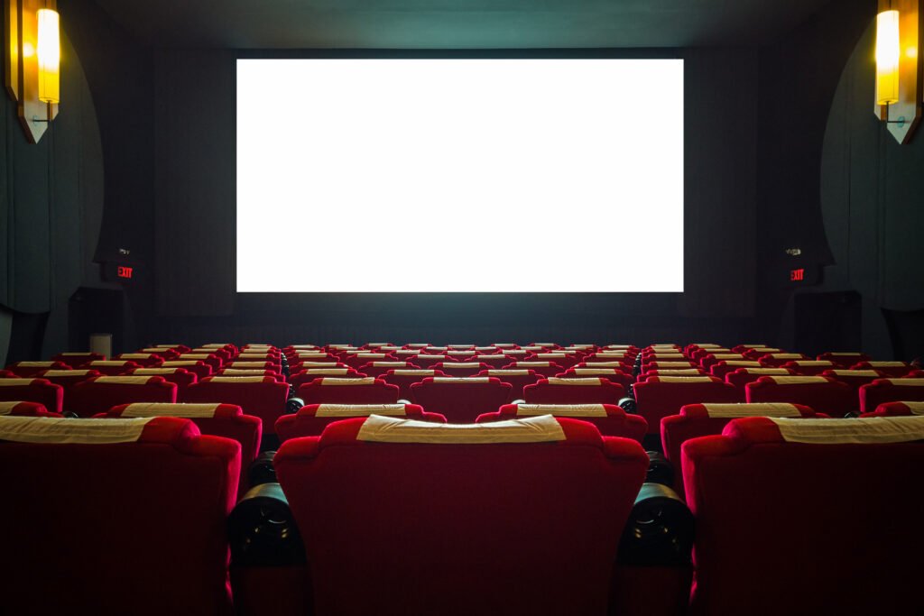 película Canelones: sala de cine con butacas rojas y pantalla iluminada