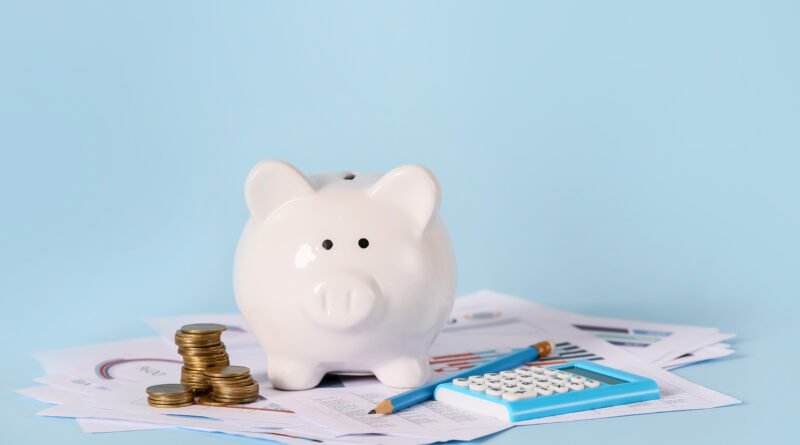 plazo fijo: alcancía con monedas, calculadora y documentos de ahorro