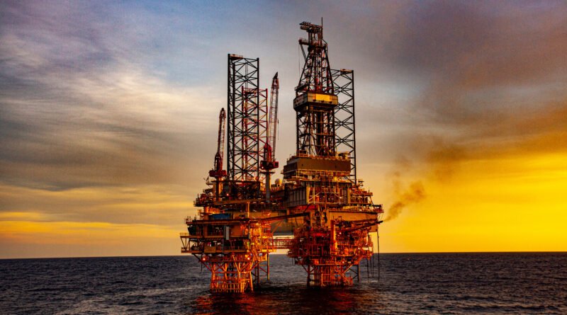 producción de petróleo: torre de perforación al atardecer
