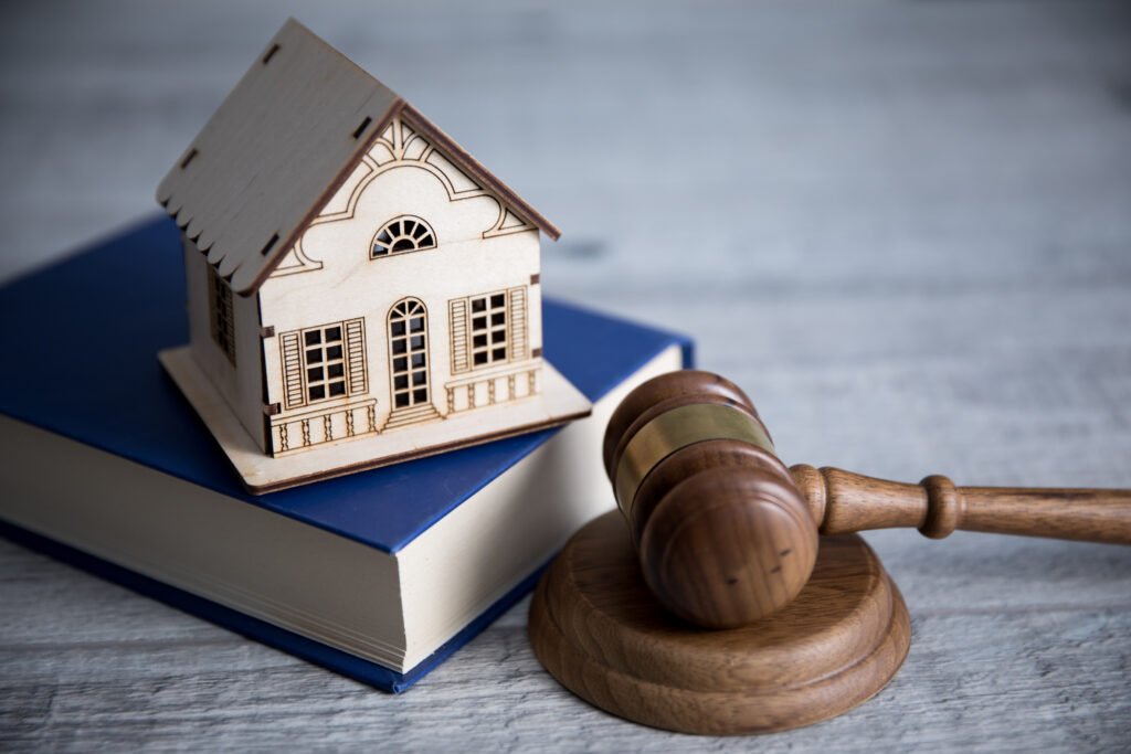 propiedad privada: mazo de juez junto a una casa en miniatura sobre un escritorio