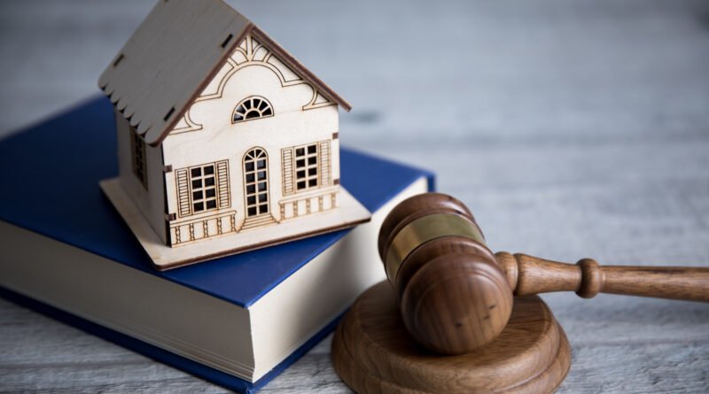 propiedad privada: mazo de juez junto a una casa en miniatura sobre un escritorio