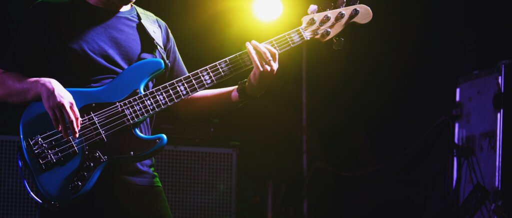 Pucho Ponce: manos tocando un bajo eléctrico en un escenario