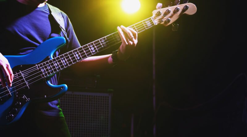 Pucho Ponce: manos tocando un bajo eléctrico en un escenario