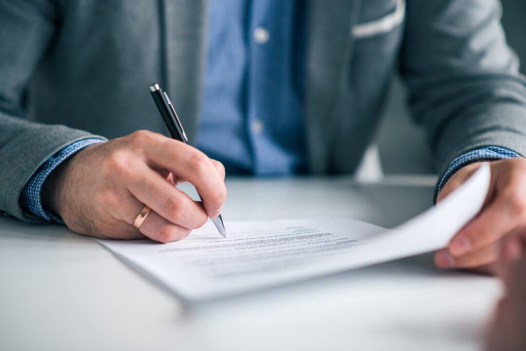 reforma laboral: mano firmando un contrato de trabajo en primer plano
