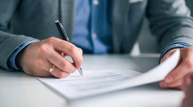 reforma laboral: mano firmando un contrato de trabajo en primer plano