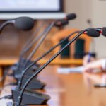 renuncia de Coudet: micrófonos de conferencia de prensa sobre una mesa
