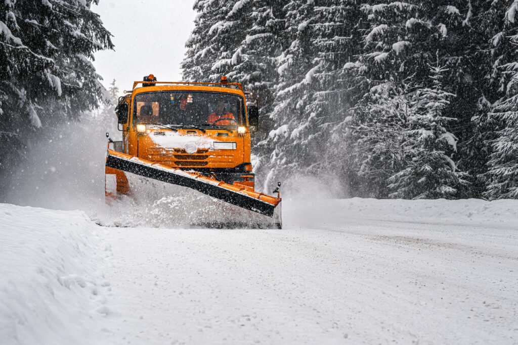 rescate en la nieve: máquina quitanieves despejando un camino de montaña