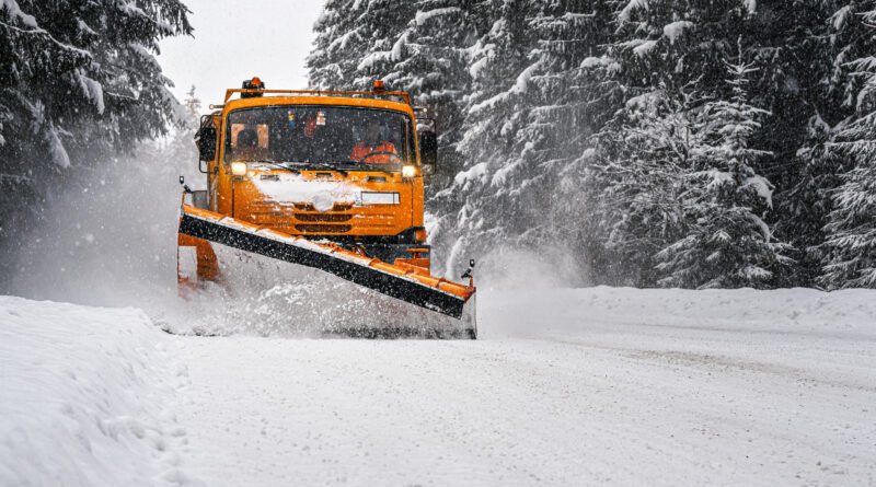 rescate en la nieve: máquina quitanieves despejando un camino de montaña