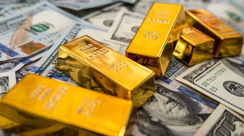 reservas del Banco Central: billetes de dólar junto a un lingote de oro