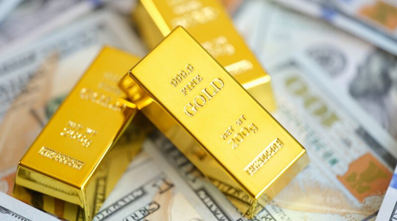 Reservas del BCRA: lingotes de oro apilados sobre billetes de dólar