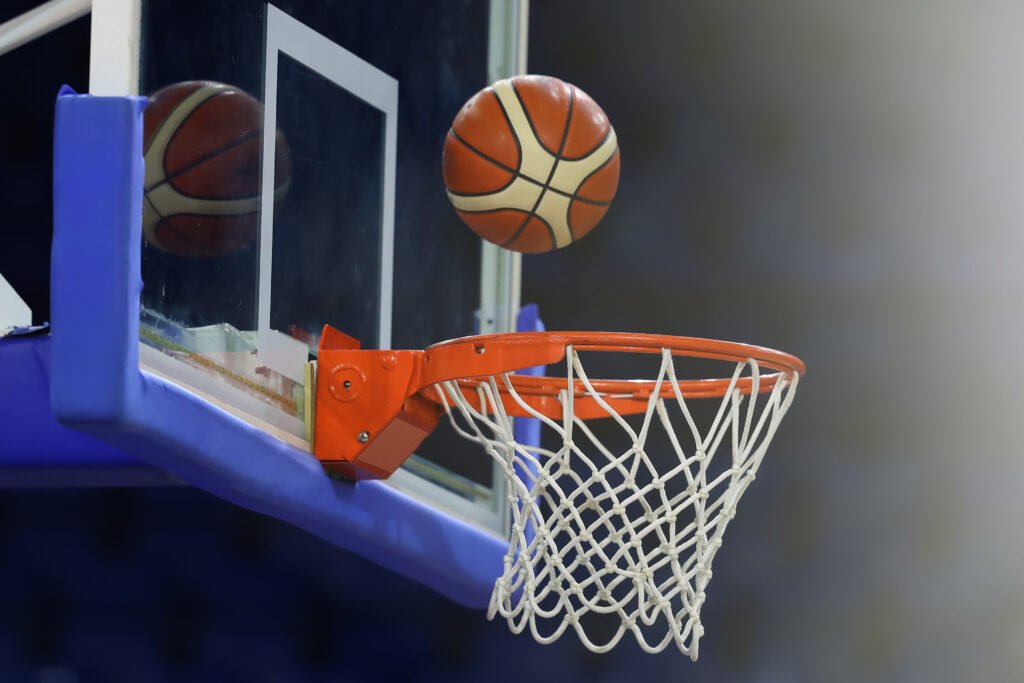 selección de básquet: pelota de básquet entrando al aro en una cancha