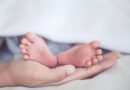 Tasa de natalidad: pies de un bebé recién nacido en las manos de su madre