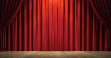 Teatro musical: escenario con cortina roja y un foco de luz