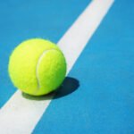 US Open: pelota de tenis sobre la línea blanca de una cancha dura