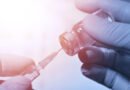 vacunación contra el dengue: frasco de vacuna y jeringa sobre fondo médico