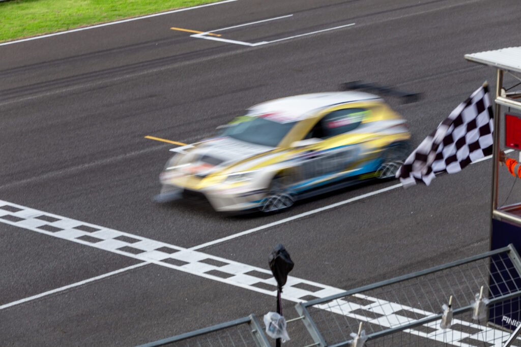 vuelta de la Fórmula 1: auto de carreras cruzando la meta con bandera a cuadros