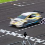 vuelta de la Fórmula 1: auto de carreras cruzando la meta con bandera a cuadros