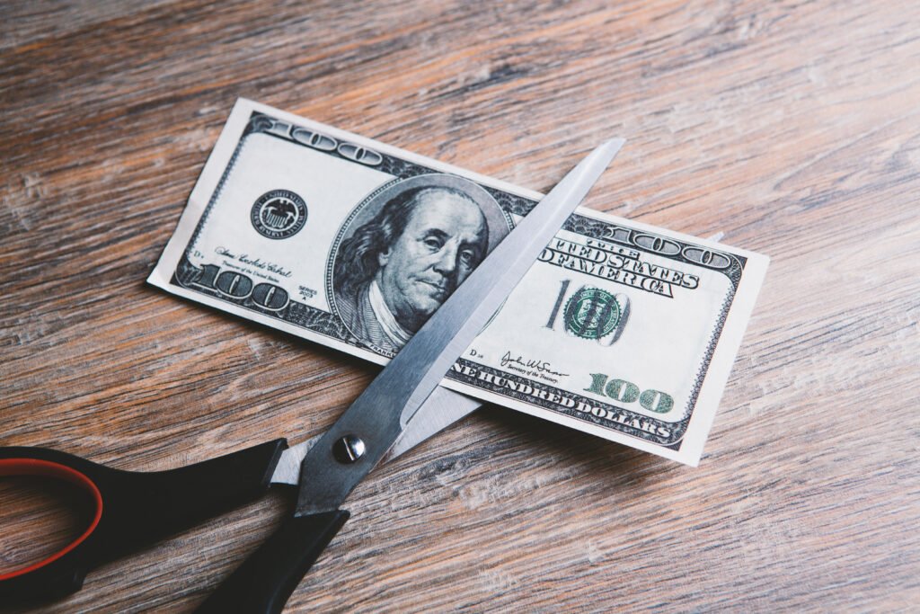ajuste del gasto: tijera cortando un billete