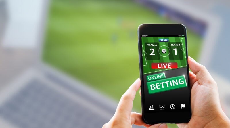 apuestas online: manos sosteniendo un teléfono con una app de apuestas