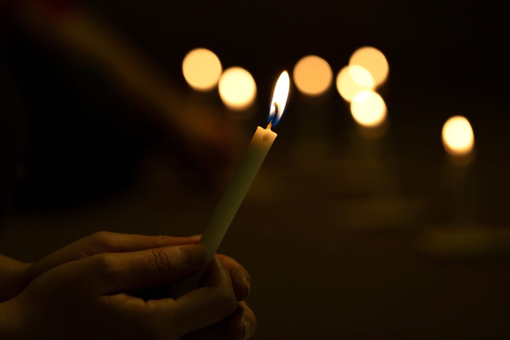 atentado a Cristina Kirchner: manos encendiendo una vela en un acto