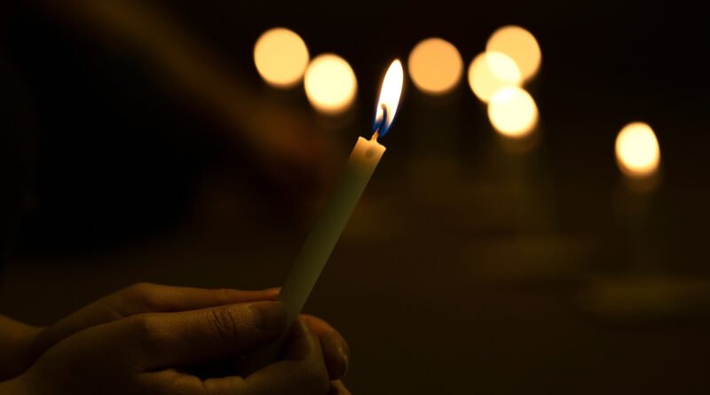 atentado a Cristina Kirchner: manos encendiendo una vela en un acto