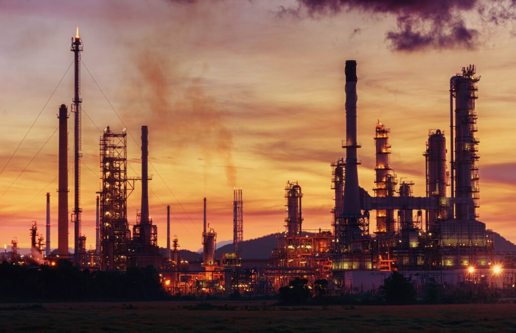 caucho sintético: planta petroquímica con cañerías al atardecer