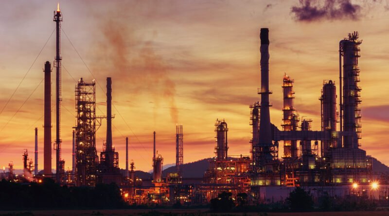 caucho sintético: planta petroquímica con cañerías al atardecer