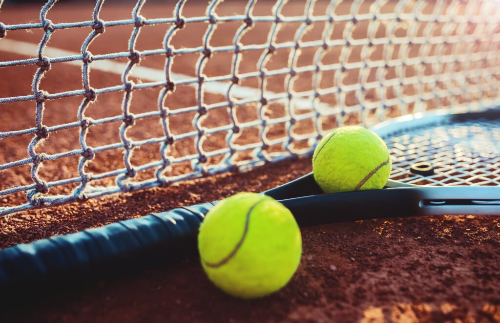 derrota de Cerúndolo: pelota y raqueta de tenis sobre la cancha