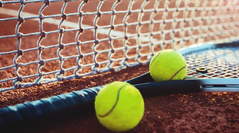 derrota de Cerúndolo: pelota y raqueta de tenis sobre la cancha
