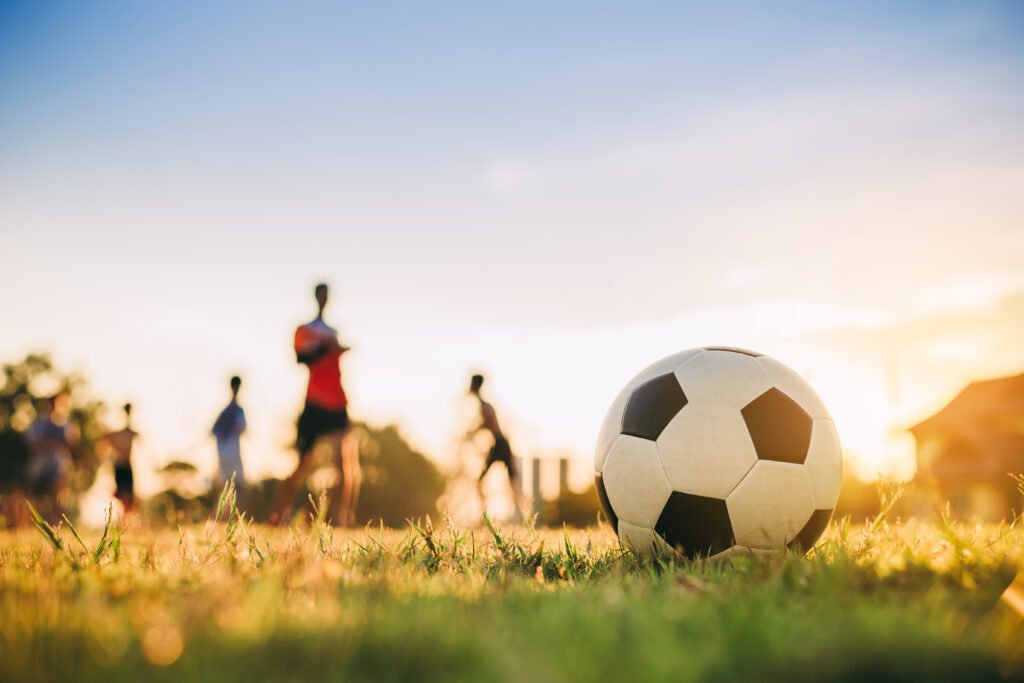 clubes de barrio: cancha comunitaria de fútbol al atardecer