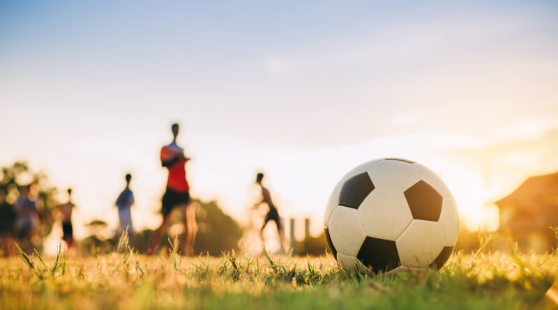 clubes de barrio: cancha comunitaria de fútbol al atardecer