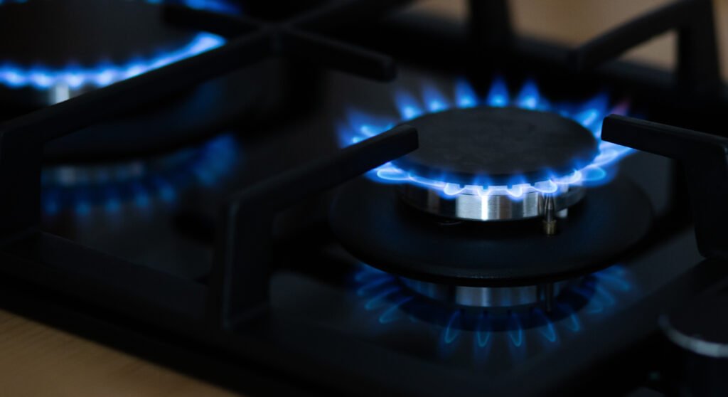 escape de gas: llama azul de una hornalla a gas encendida