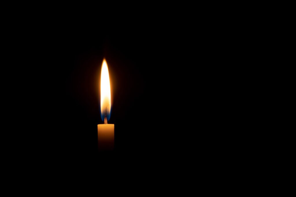 Femicidio en Rosario: vela encendida sobre fondo oscuro en clima de memoria