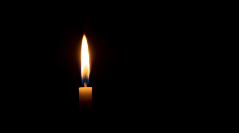 Femicidio en Rosario: vela encendida sobre fondo oscuro en clima de memoria